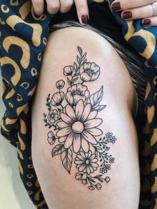 tatuagem feminina de flores na coxa