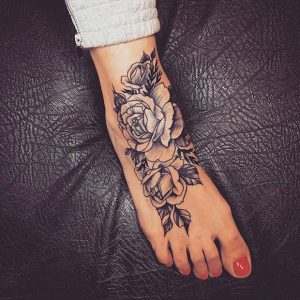tatuagem feminina no pé de flores