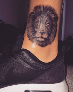 Tatuagem feminina de leão no tornozelo ou pé