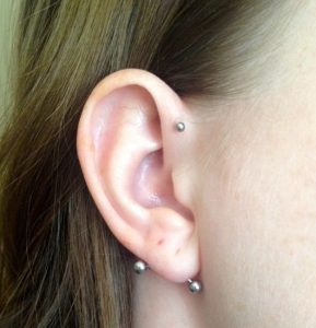 piercing na orelha lóbulo horizontal transversal