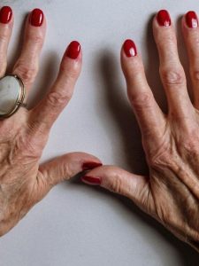 mãos mais velhas com esmalte vermelho