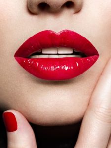 mulher com lábios e unhas em vermelho