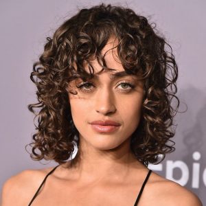 mulher com franja desfiada em cabelo cacheado