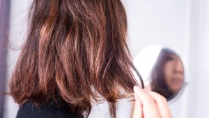 mulher de costas com cabelo com frizz