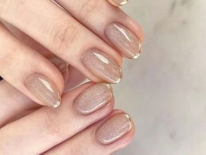 Unhas nude com glitter fino e francesinnha dourado