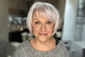 mulher com cabelo grisalho em corte bob com franja