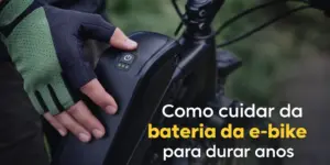 Pessoa com luvas ajustando bateria de e-bike ao ar livre